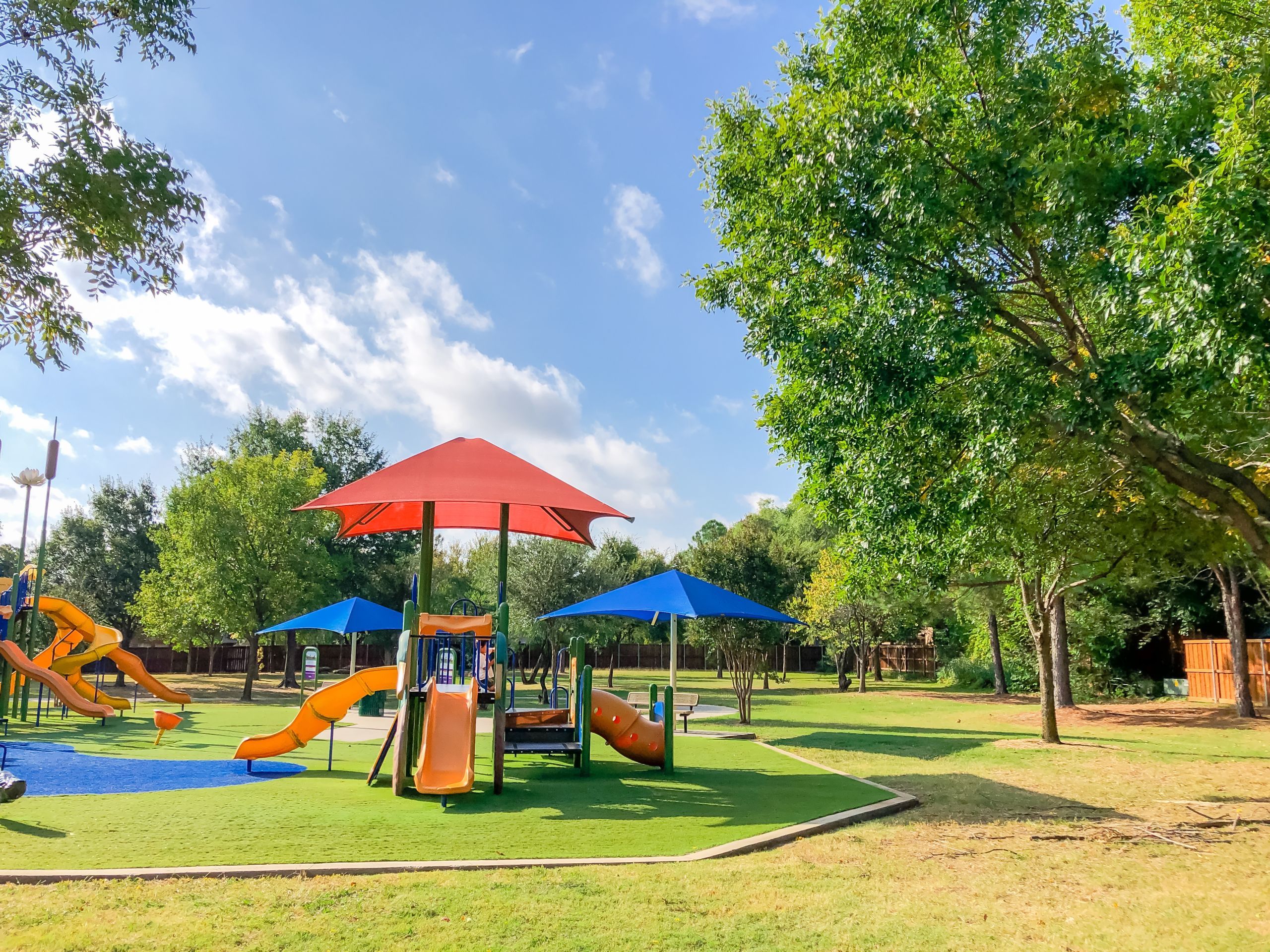 Residential area playground with sun shade sails and artificial grass in Flower Mound, Texas, USA